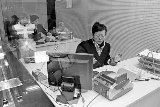 2月16日，鄭州市自來水總公司鄭東新區(qū)一營業(yè)廳，柜臺內(nèi)工作人員正在為市民辦理業(yè)務