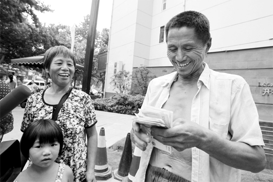 昨日，鄭州市明達路與豐慶路交叉口西300米路南，來自中牟的瓜農(nóng)拿到西瓜款，笑開顏東方今報記者袁曉強