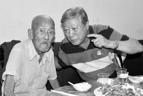 昨日，來(lái)自北京的英雄后代胡冠軍（右）專門趕到西平縣看望抗戰(zhàn)老兵孫殿修老人