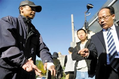 常林鋒在法院外展示雙手，他稱被燙傷的手因刑訊逼供且未得到及時(shí)救治