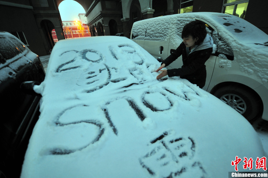 11月18日，行人在車輛的積雪上涂鴉。
