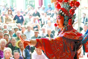 圖為8月15日戲曲演員在“流動(dòng)舞臺(tái)車”上表演傳統(tǒng)地方戲《穆桂英下山》。