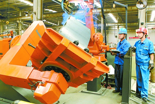 圖為龍工集團中原公司的職工正在操作機器人焊接裝載機。