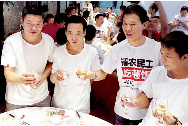 活動(dòng)發(fā)起人張楠（右二）給農(nóng)民工敬酒。