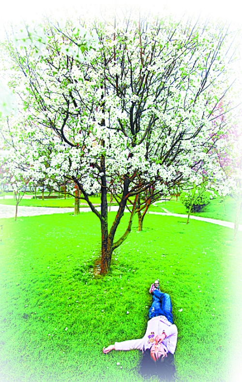 　孩子愜意地躺在社區(qū)內(nèi)的草坪上。