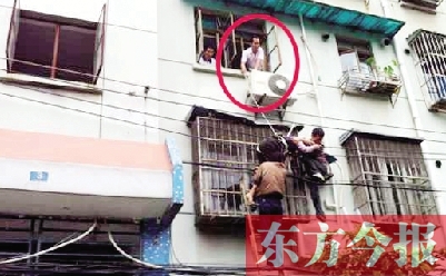 施救現(xiàn)場，劉鵬（圈內(nèi)）先用繩子捆住老太確保安全 勞動報記者 郭娜 供圖