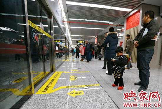 小朋友在等候區(qū)內(nèi)等待地鐵。