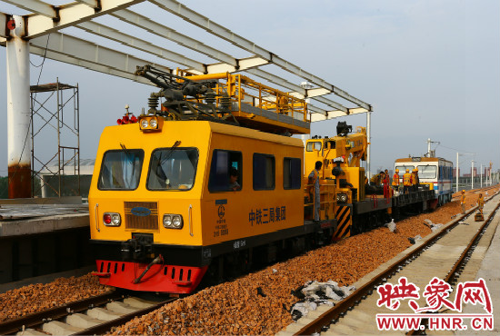 一列工程車從站臺(tái)駛過(guò)。