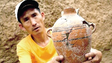 　　考古工作人員展示出土的仰韶文化時(shí)期代表性彩陶。