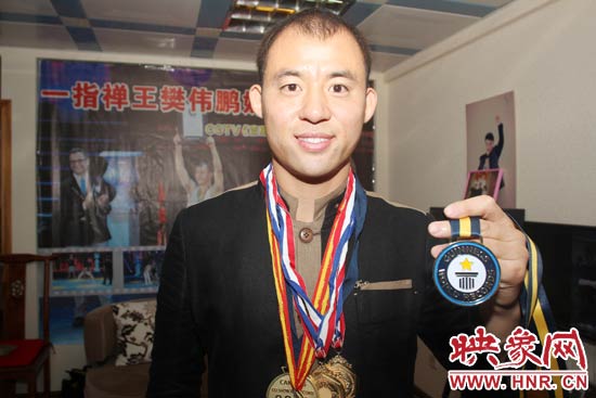 樊偉鵬向大家展示自己剛獲得的吉尼斯獎(jiǎng)牌。