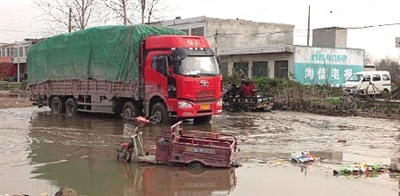 老人的電動三輪車還陷在泥坑中 老人的電動三輪車還陷在泥坑中