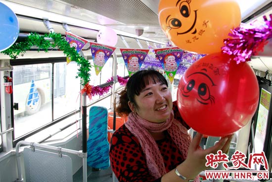 鄭州快速公交B3區(qū)間線車長李鵬云在車廂里懸掛氣球，布置圣誕車廂，營造歡樂圣誕氛圍