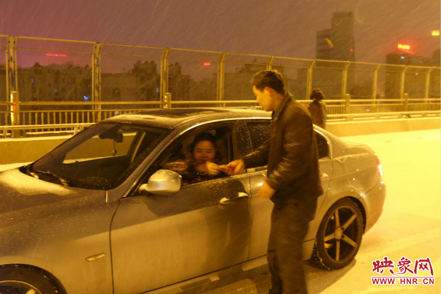 “推車人”幫助一輛車上坡后，收取“勞務費”。