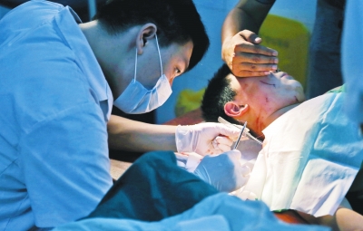 孩子身上有7道傷痕，其中兩道需要縫合，其他的均為擦傷，醫(yī)生正對(duì)他施治。