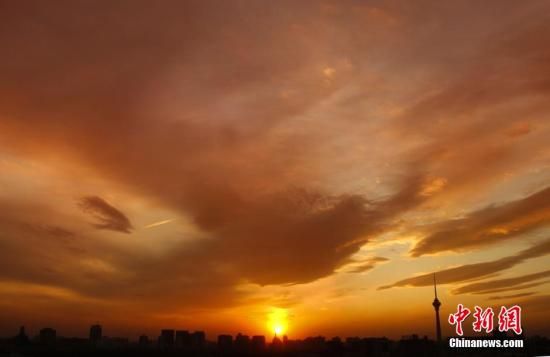 12月8日下午，強(qiáng)烈的西北風(fēng)光臨北京，吹散了籠罩全城上空的霧霾，冬日罕見的艷麗晚霞映紅了半邊天。