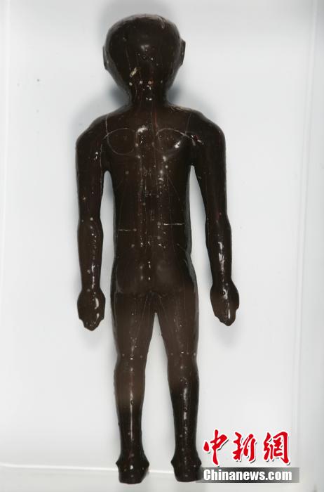 圖為出土的人體經(jīng)穴漆俑。