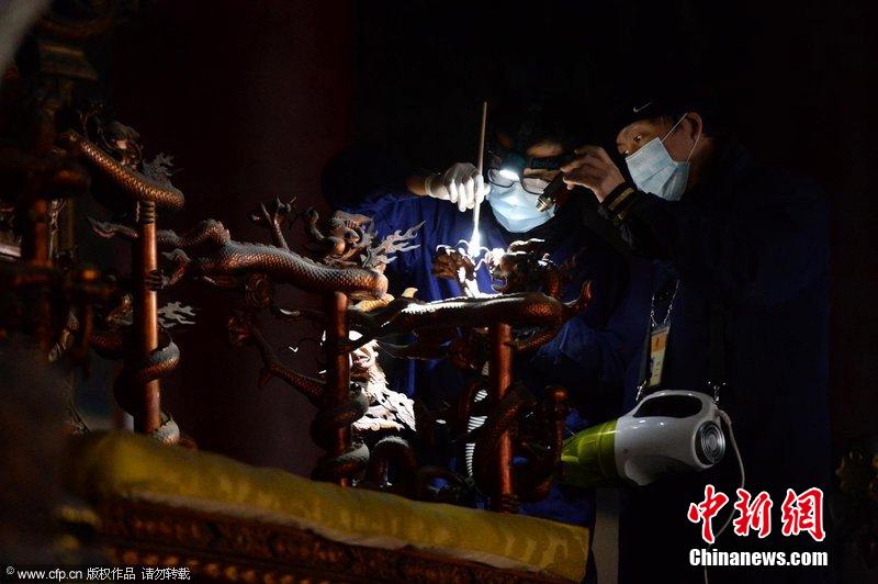 圖為工作人員使用軟毛刷和吸塵器對(duì)太和殿的金漆雕龍寶座除塵。