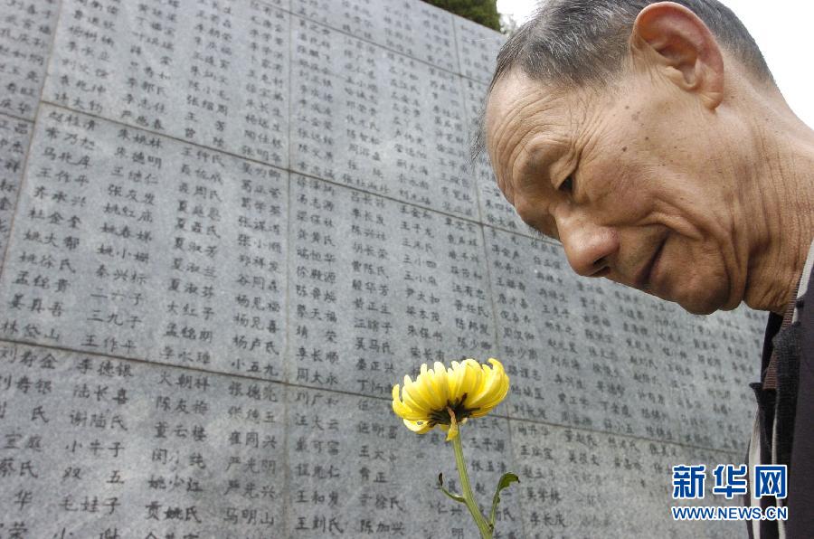 2006年4月5日，74歲的南京大屠殺幸存者佘子清手捧鮮花，祭奠被日軍殺害的母親。