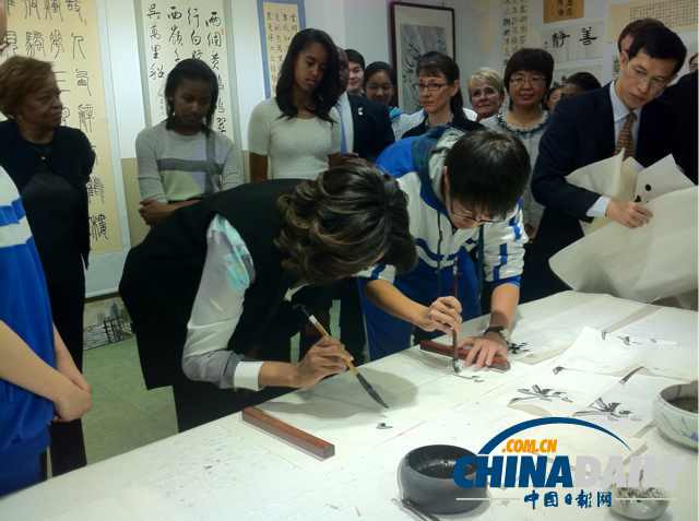 　北京時間3月21日，美國第一夫人米歇爾參觀北師大二附中時，與學(xué)生一起練習(xí)書法。