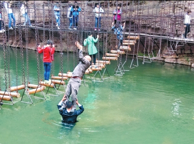 中年男游客正踩著景區(qū)安全員郭小明的肩膀過河。網(wǎng)友“@我的小名叫張孩”供圖