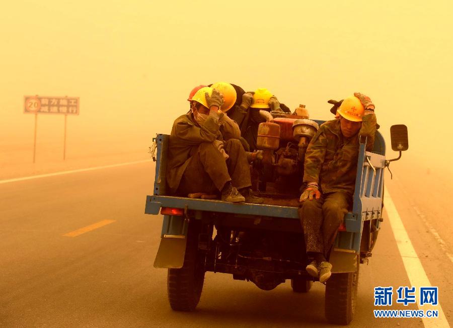 4月23日，一輛拉載公路施工人員的三輪車在沙塵暴中行駛在酒泉市瓜州縣城郊的公路上。