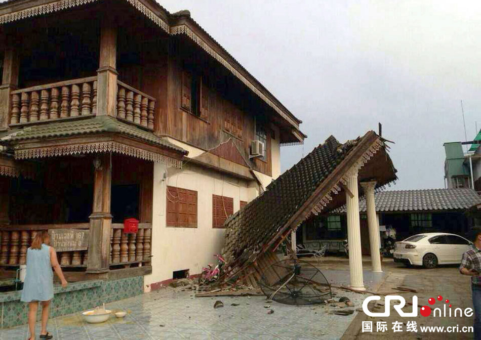 當(dāng)?shù)貢r間2014年5月5日，泰國清萊，一名婦女看著受損的房屋。 圖片來源：東方IC