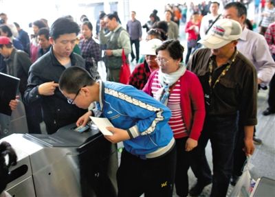 去年5月5日，14號線園博園站，乘客刷卡出地鐵。北京公交地鐵將實行計程票制，多乘坐多付費。