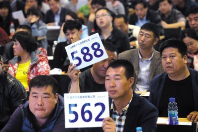 昨日，拍賣現(xiàn)場競拍者舉牌競拍。新京報記者