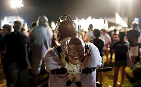 9月4日，新加坡，執(zhí)政黨的一場集會上，一名支持者背著一個李光耀的人偶。