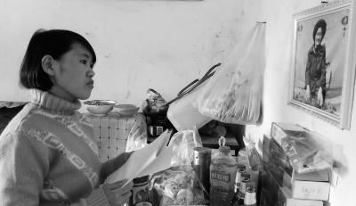 錢仁鳳站在母親遺像前。未能見母親最后一面是她的一大遺憾。