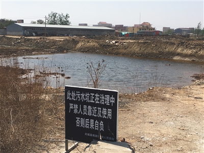 化肥廠滲坑的三分之一經(jīng)過治理，但水質(zhì)仍然呈黃褐色。