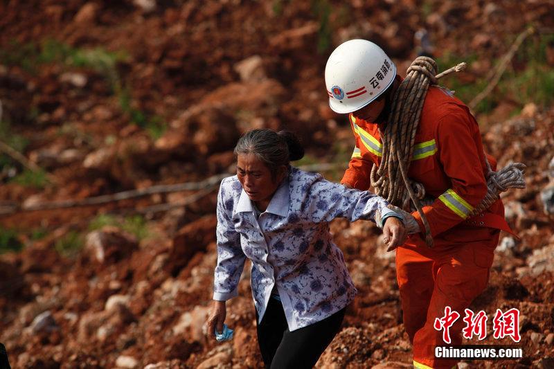 一位消防戰(zhàn)士將一位失去親人的老人扶離滑坡點(diǎn)。