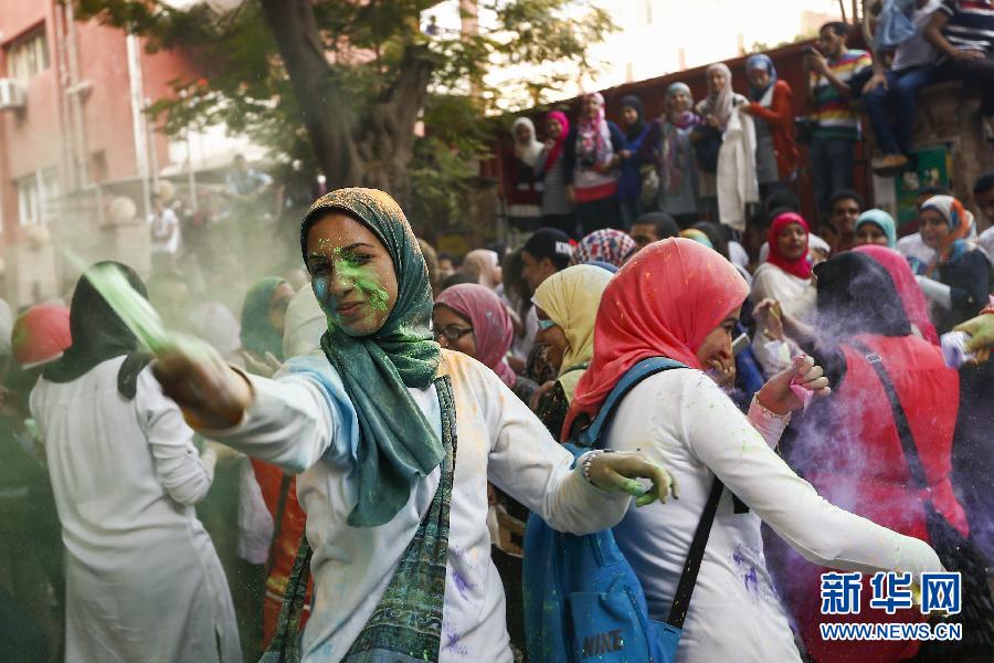 10月16日，在埃及首都開羅，一名女青年在“彩色跑”活動(dòng)中拋撒彩色粉末。