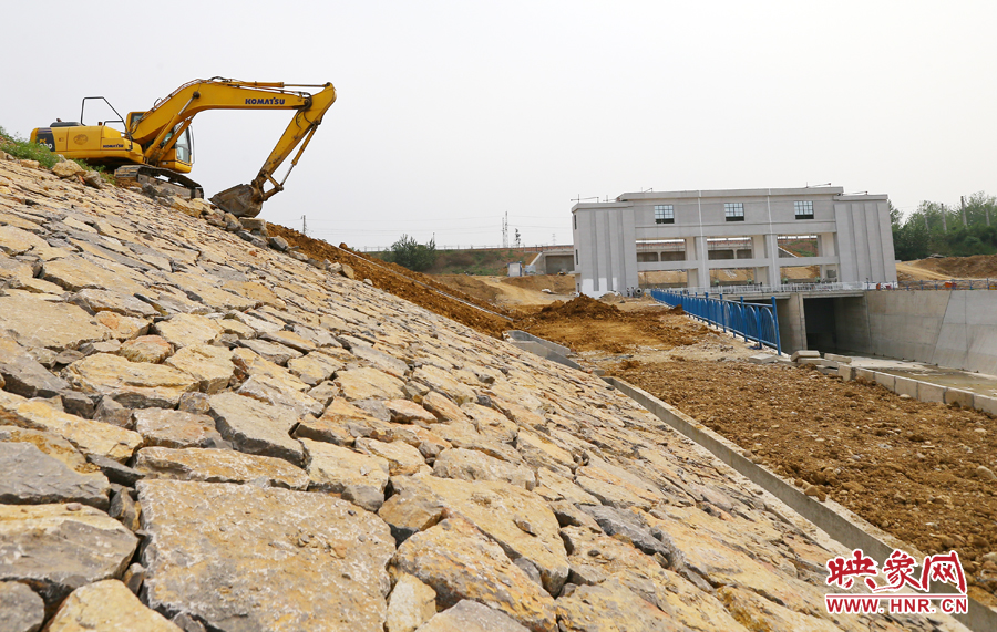 護堤上挖掘機進(jìn)行著最后的整理工作