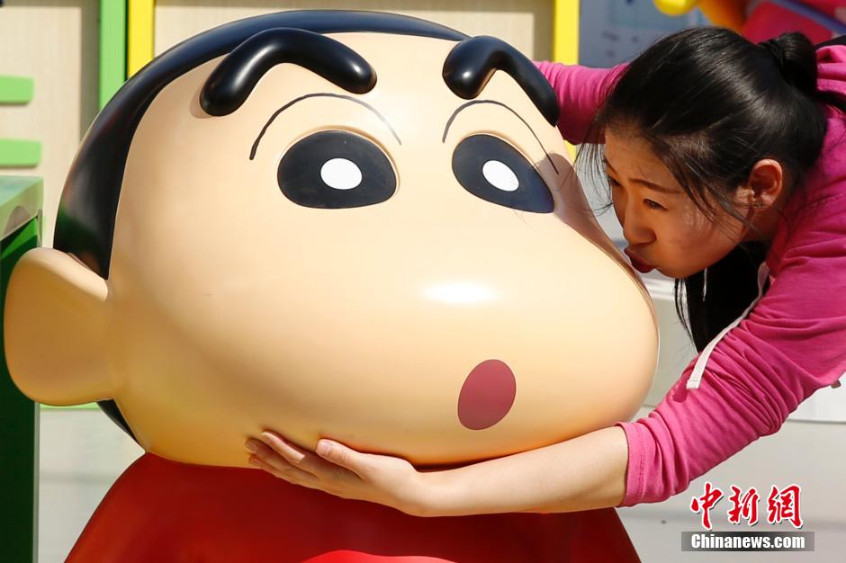 4月22日，游客與蠟筆小新合影?！跋灩P小新25周年紀(jì)念特展”日前在北京開展，吸引了不少市民游客。