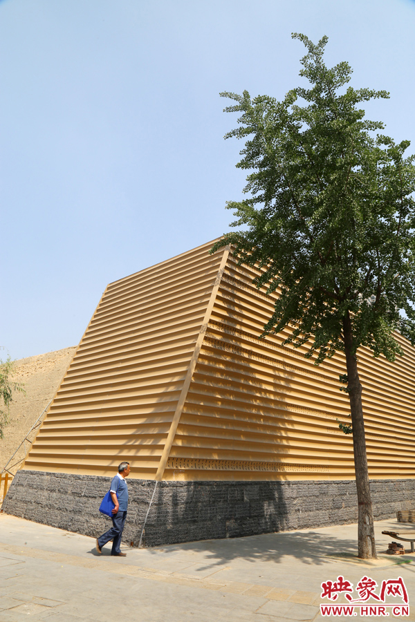 一名路人從“土豪金”保護(hù)殼前經(jīng)過。