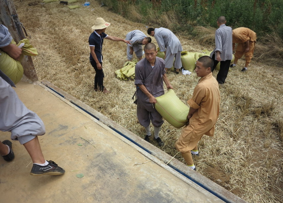 武僧將打包后的糧食集中至運(yùn)輸車輛上。