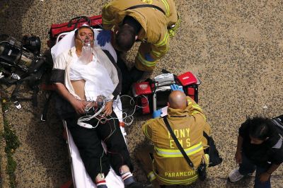 2日，救援人員在美國紐約地鐵事故車輛內緊急疏散一名受傷乘客。圖/CFP