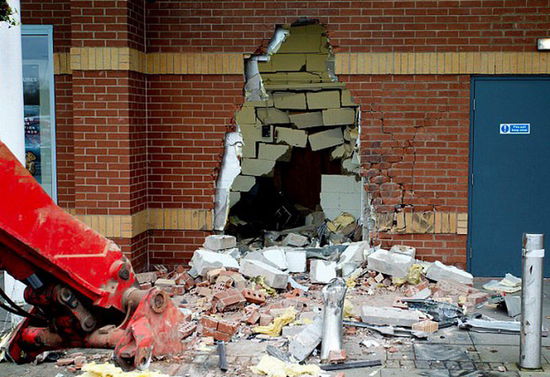 劫匪利用挖掘機(jī)的機(jī)械臂移走ATM機(jī)，留下滿地狼藉