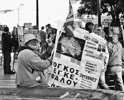 自債務危機爆發(fā)以來，希臘承諾實施以減薪、增稅、裁員和私有化為主要內(nèi)容的緊縮和改革政策。一系列的緊縮措施使民眾生活受到嚴重影響，約1/4的家庭陷入貧困。圖為今年1月希臘大選期間，在雅典市中心國會大廈前廣場乞討的老人。