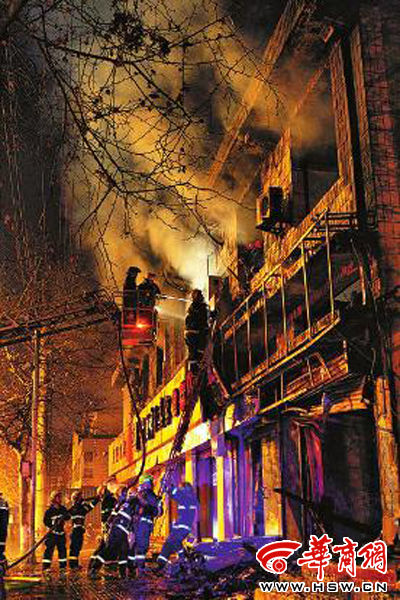 昨日22時(shí)10分，西安市豐慶路南小巷南口，消防官兵架梯子登上二樓施救 本組圖片由本報(bào)記者 閆文青 攝