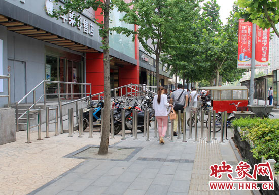 圖中道路左側(cè)的無障礙通道被鋼管隔離,右側(cè)的盲道也被侵占。