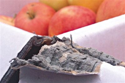 8月29日，新發(fā)地市場，一箱用“加重紙箱”包裝的蘋果正待售，紙箱夾層內(nèi)灰黑色的增重填充物清晰可見