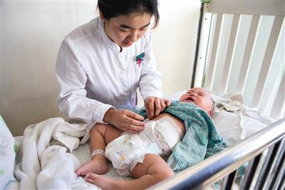 昨日，北京兒童醫(yī)院，護(hù)士為即將出院的被扎鋼針女?huà)霗z查傷口恢復(fù)情況。記者 高瑋 攝