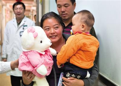 昨日上午，被扎針女?huà)氲哪赣H抱著孩子和醫(yī)護(hù)人員送的玩偶準(zhǔn)備出院，院方稱(chēng)孩子術(shù)后恢復(fù)良好。記者 高瑋 攝