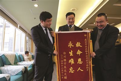 張乃余(中)和兩位救人的同伴一塊領(lǐng)獎(jiǎng)。