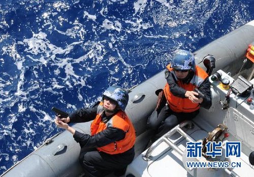 　3月28日，十余名臨檢拿捕隊員乘小艇駛至模擬可疑商船下方水面。