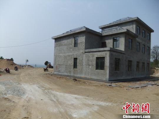 鴨河水庫庫區(qū)邊的新建別墅，一面墻上寫著“拆”，另一邊在加緊施工。吳揚　攝