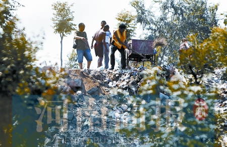 有人正在傾倒建筑垃圾，不遠處就是村民的水井